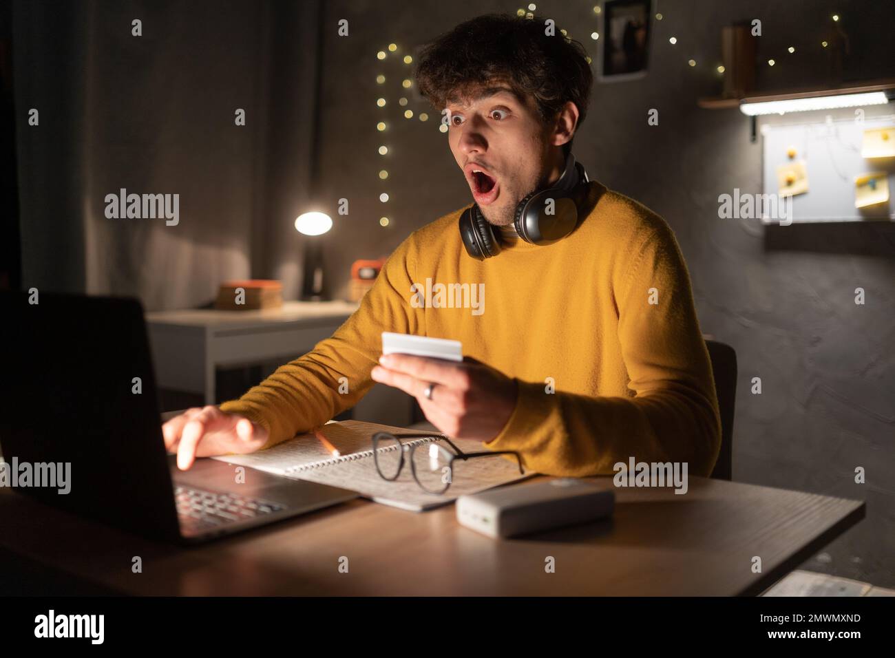 Scioccato studente con notebook non ha soldi sulla sua carta di credito. Spazio di copia Foto Stock