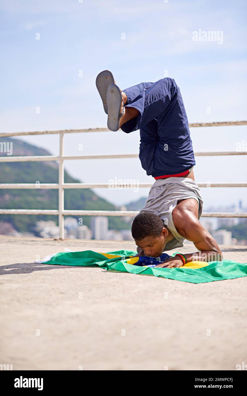 Azione di bilanciamento. Inquadratura ad angolo basso di un giovane breakdancer maschile in un ambiente urbano. Foto Stock