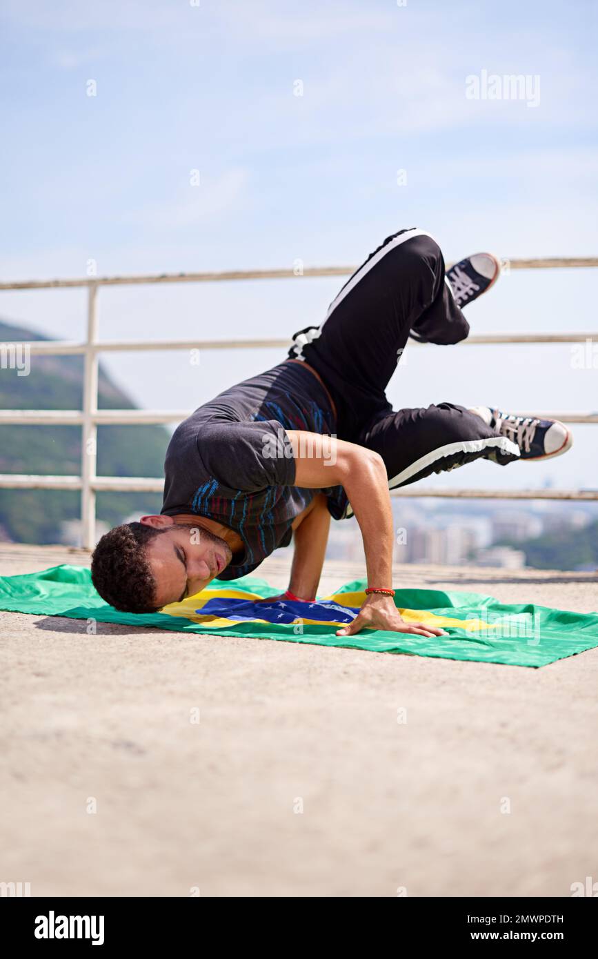 Capoeira- parte della cultura brasiliana. Inquadratura ad angolo basso di un giovane breakdancer maschile in un ambiente urbano. Foto Stock