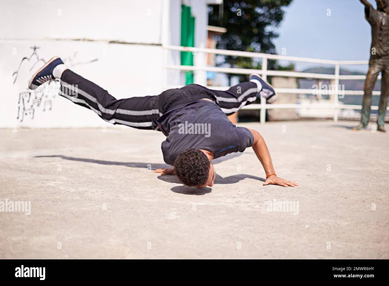 Ballare per le strade. Inquadratura ad angolo basso di un giovane breakdancer maschile in un ambiente urbano. Foto Stock