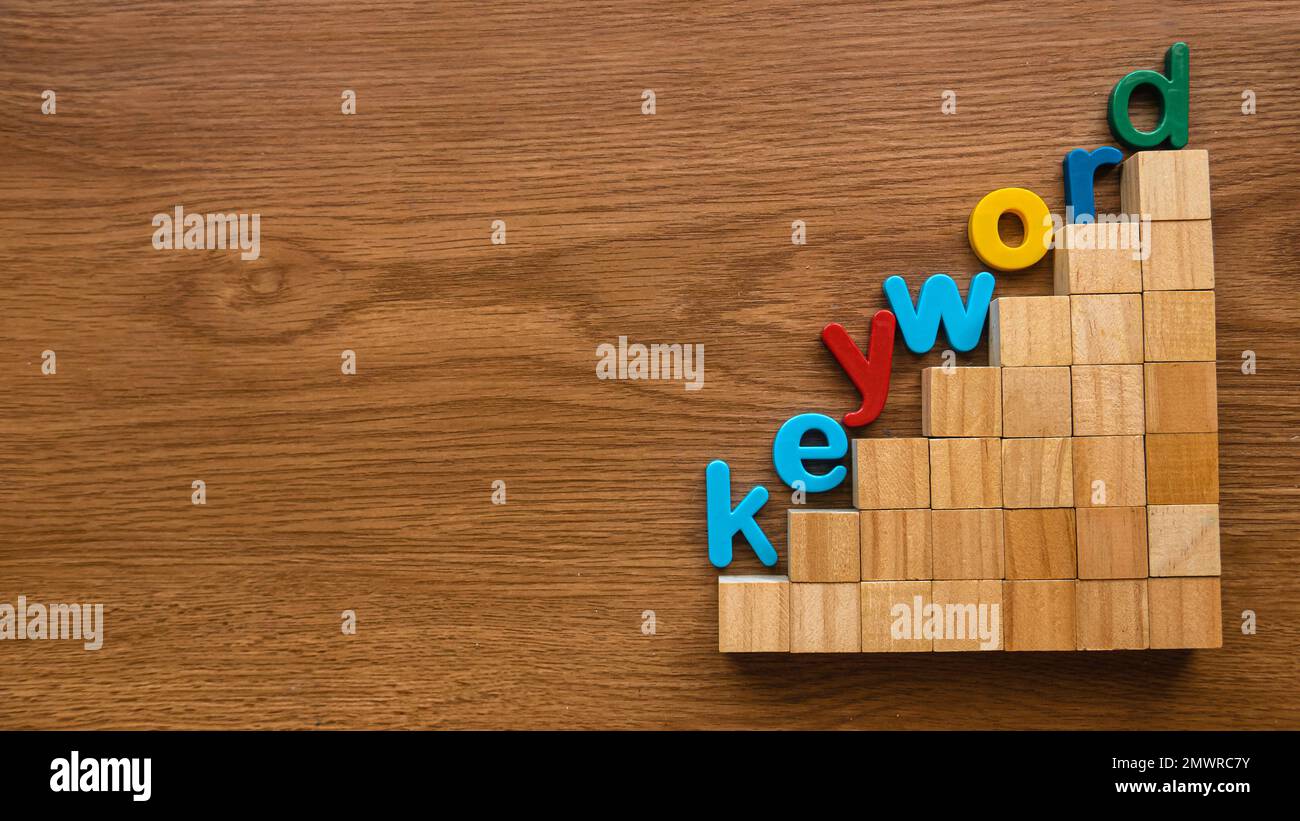 Alfabeto colorato di parola chiave su una scala di cubo di legno. Foto Stock