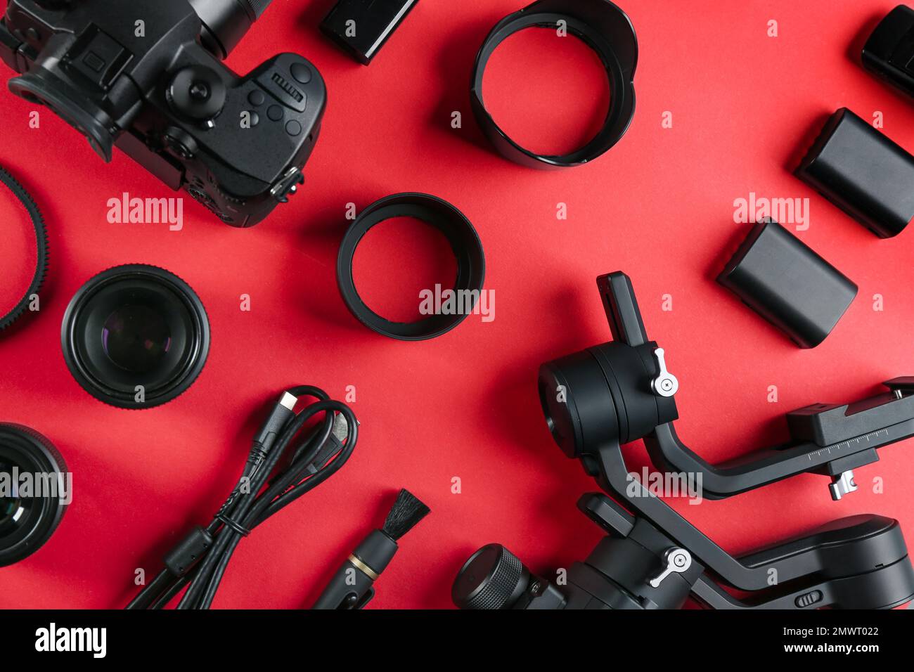 Composizione a posa piatta con macchina fotografica e attrezzatura di produzione video su sfondo rosso Foto Stock