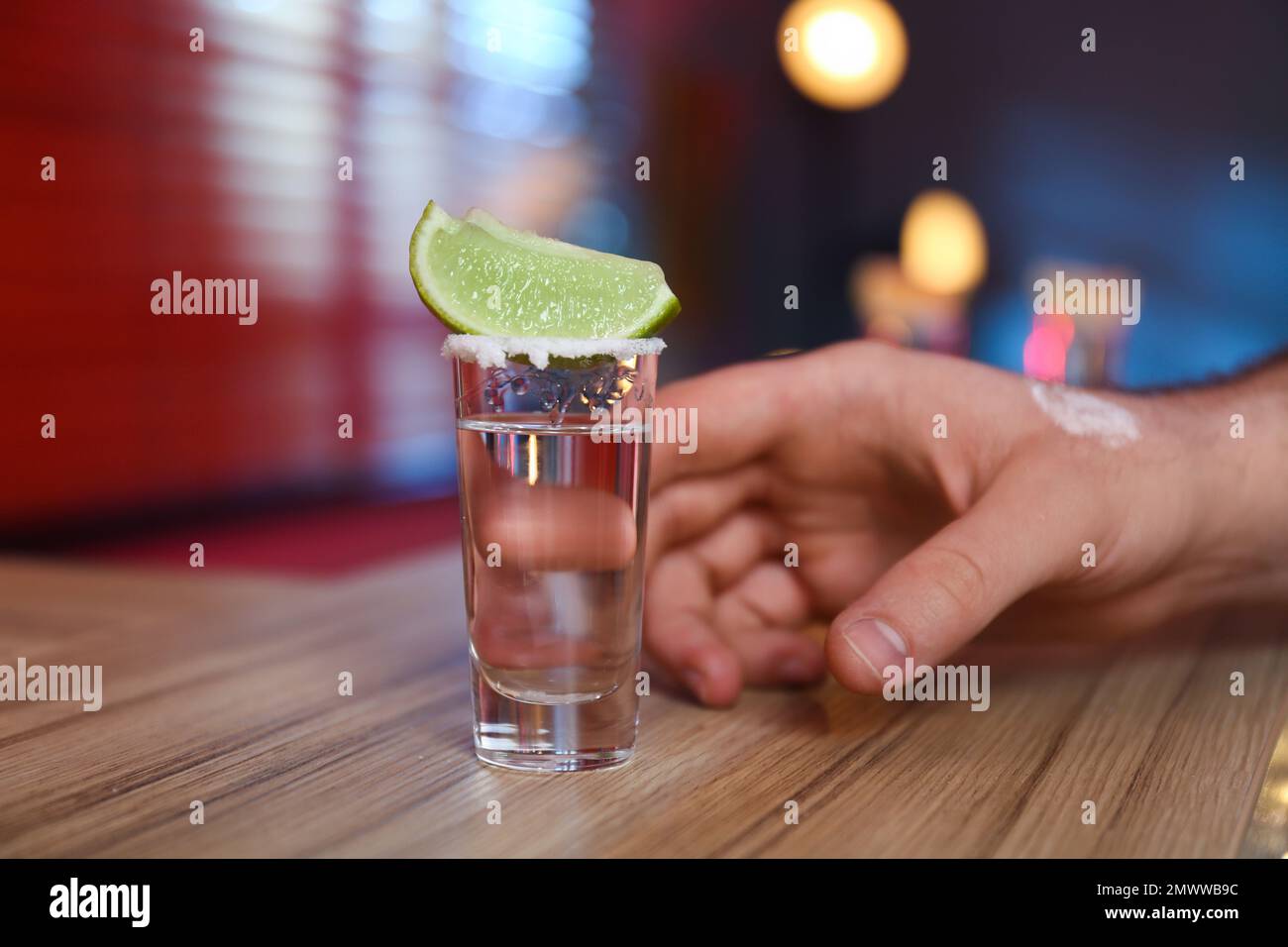 Uomo con shot di tequila messicana al bar, primo piano Foto Stock