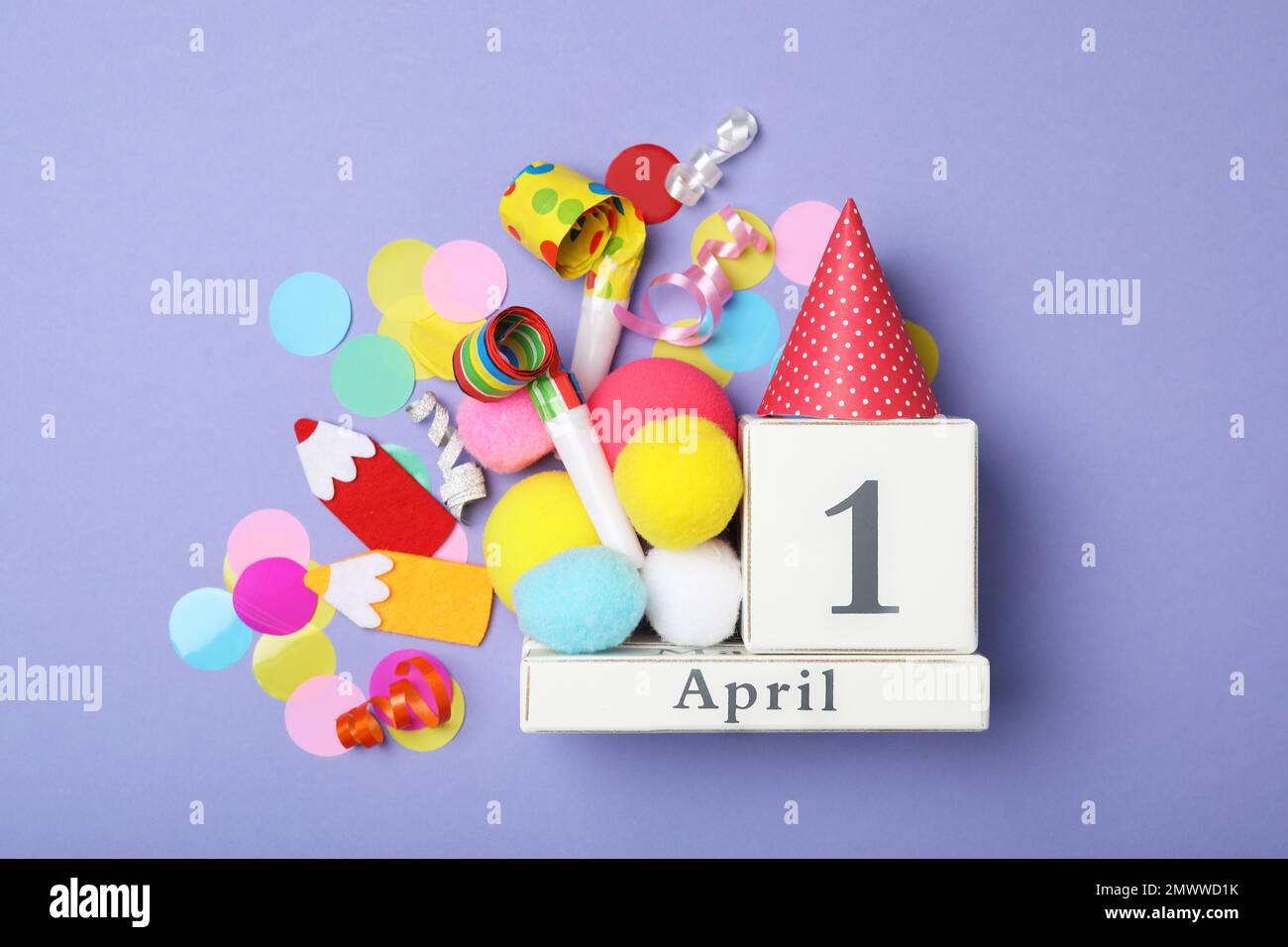 Composizione piatta con calendario a blocchi e oggetti per feste su sfondo viola. Fool's Day di aprile Foto Stock