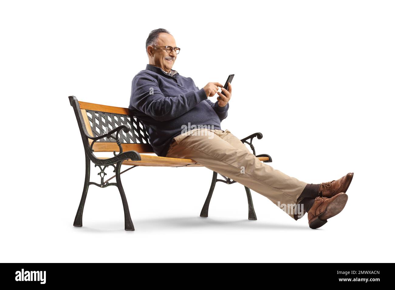 Uomo maturo seduto su una panchina e utilizzando uno smartphone isolato su sfondo bianco Foto Stock