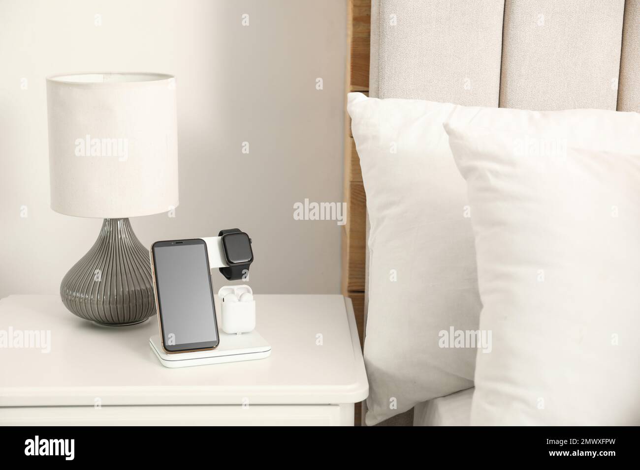 Diversi gadget in carica sul pad wireless in camera da letto. Spazio per il  testo Foto stock - Alamy