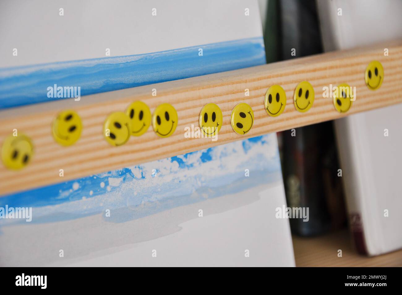 Adesivi facciali sorridenti su una libreria di legno, camera per bambini, adesivi felici Foto Stock