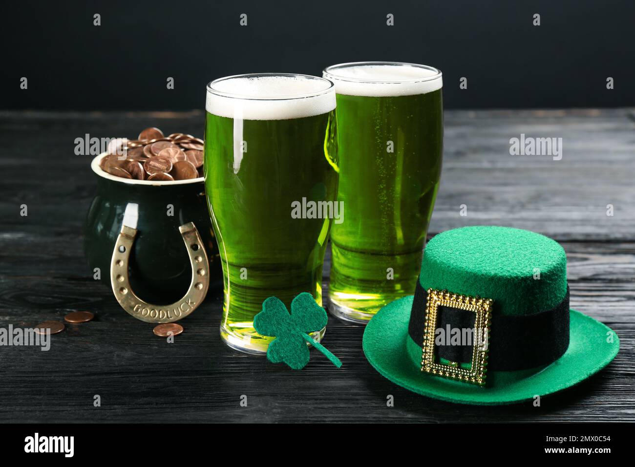 Composizione con birra verde e trifoglio su tavolo di legno nero. St Festa di Patrizio Foto Stock