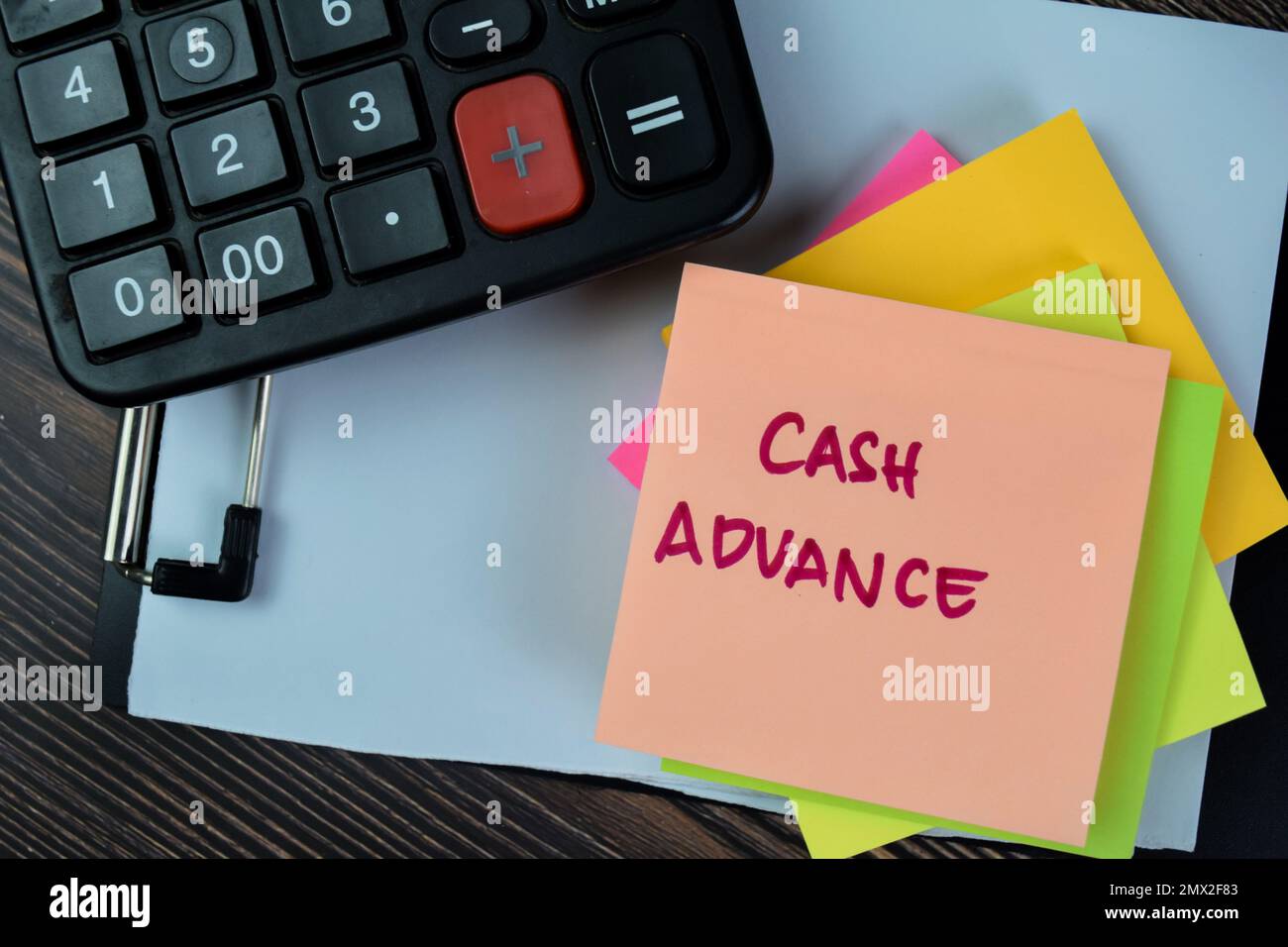 Concetto di anticipo in contanti scrivere su note appiccicose isolate su tavolo di legno. Foto Stock