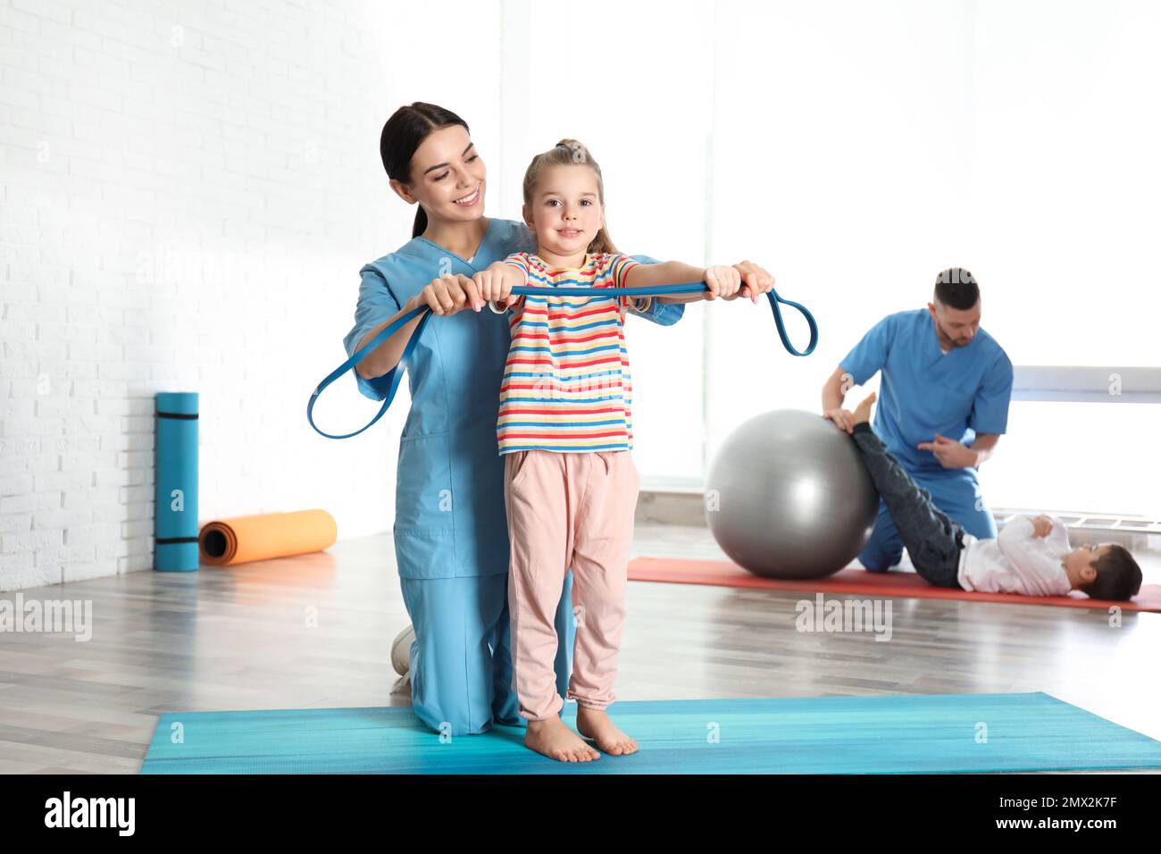 Ortopedici che lavorano con bambini piccoli in palestra ospedaliera Foto Stock