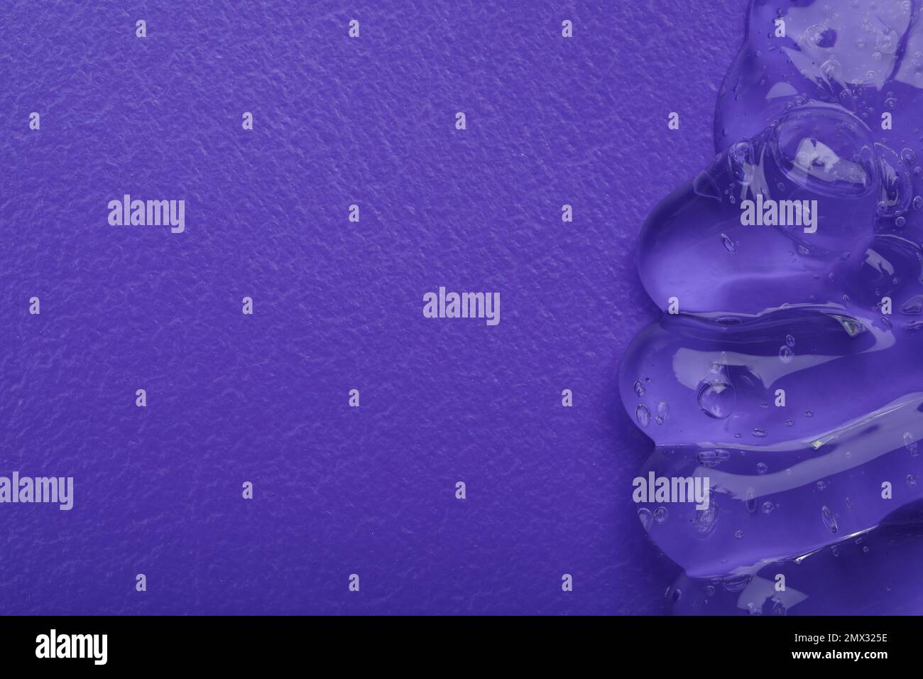Campione di gel cosmetico trasparente su sfondo viola, vista dall'alto Foto Stock