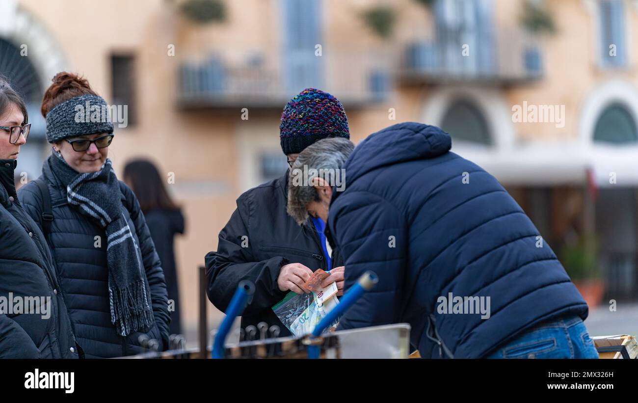 donna adulta che paga un dipinto appena acquistato da un artista per strada a roma, italia, city life concept Foto Stock