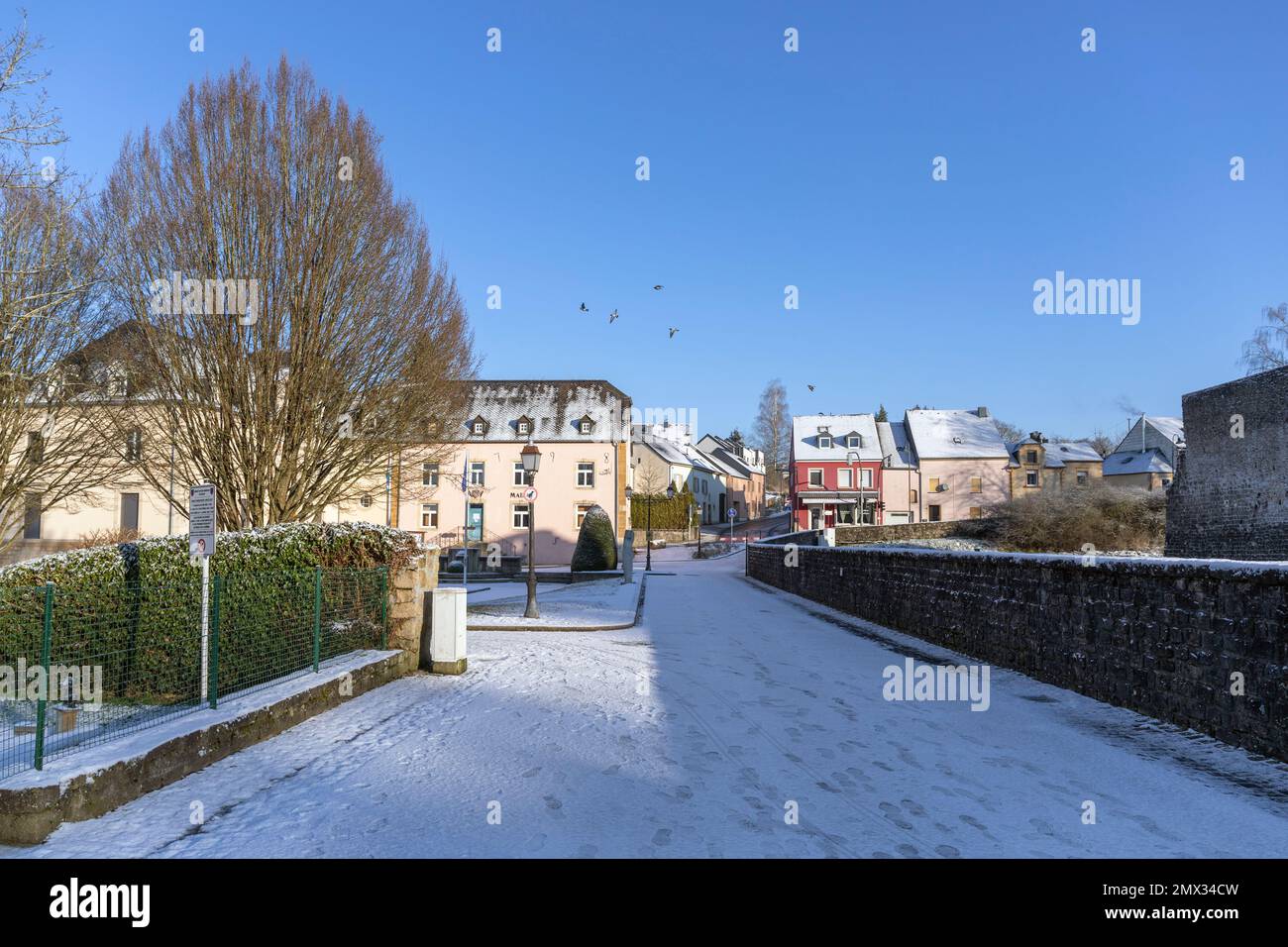 Europa, Lussemburgo, Koerich, guardando lungo Rue de l'École verso la Mairie (Municipio) nella neve d'inverno Foto Stock