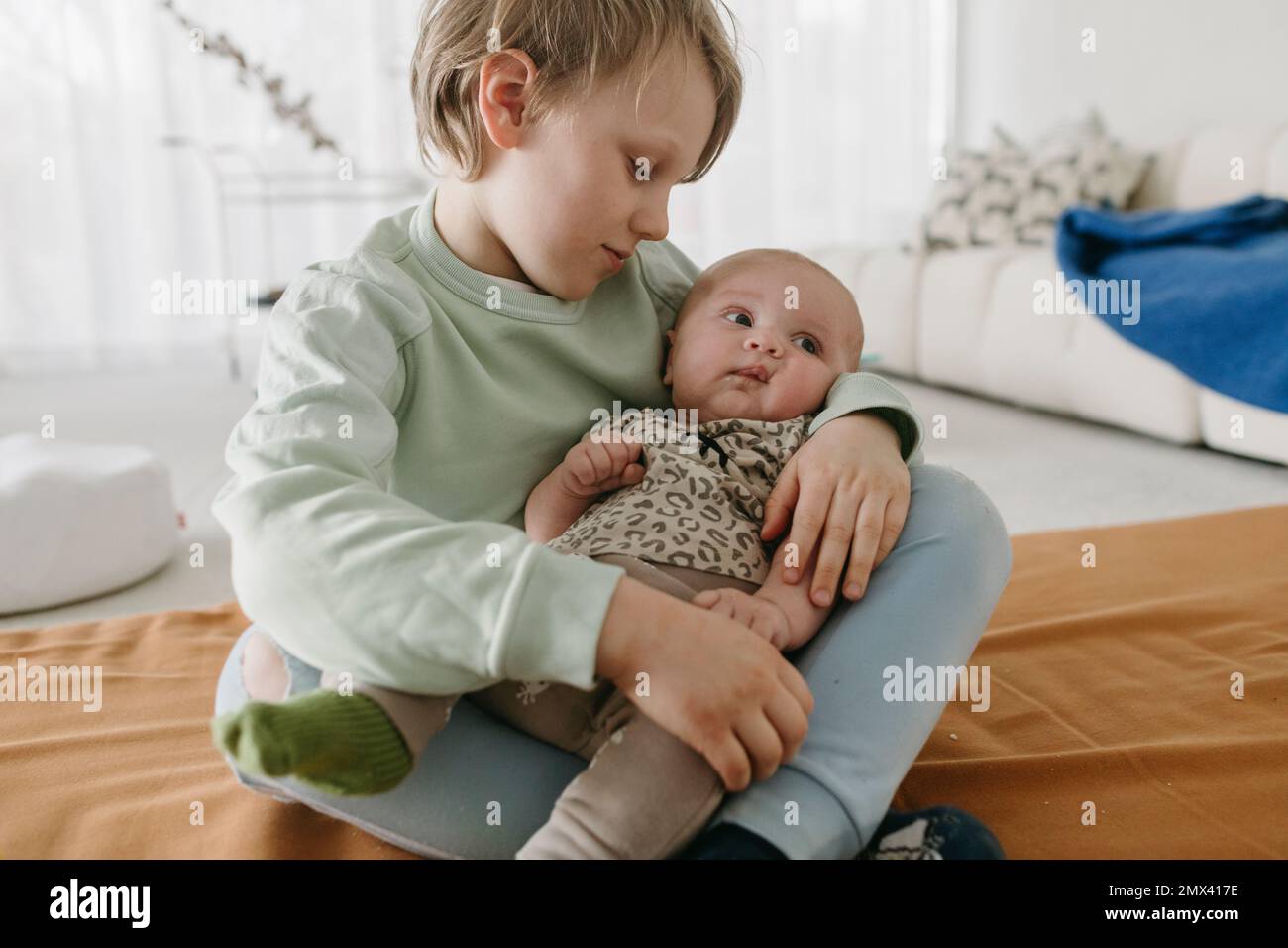 Ragazzo seduto con bambino fratello Foto Stock