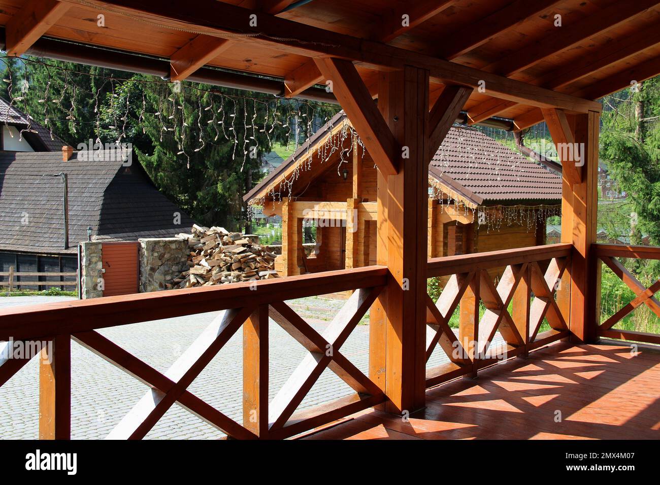 Ringhiera terrazza e patio di cottage paese con legna da ardere impilata vicino a bosco Foto Stock