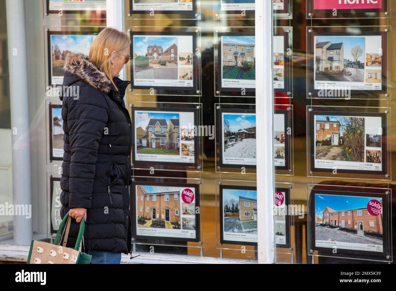 Foto datata febbraio 2nd mostra le persone che cercano nelle finestre degli agenti immobiliari a Ely, Cambs, il Giovedi mattina come è annunciato ci sarà un altro inc Foto Stock