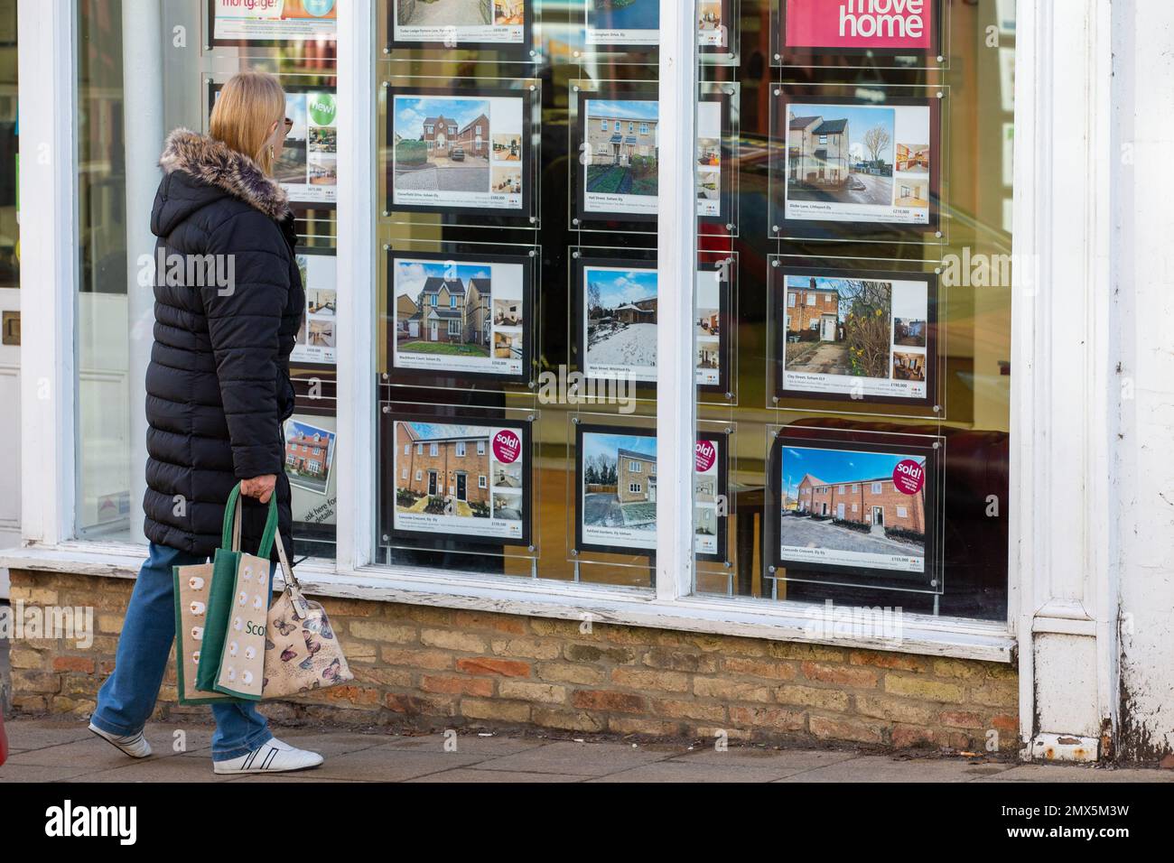 Foto datata febbraio 2nd mostra le persone che cercano nelle finestre degli agenti immobiliari a Ely, Cambs, il Giovedi mattina come è annunciato ci sarà un altro inc Foto Stock