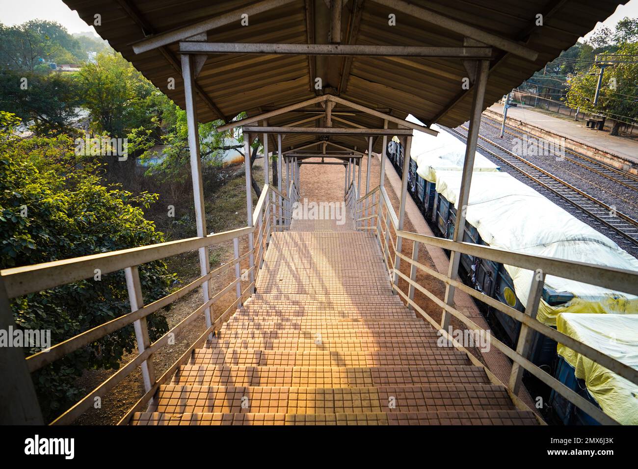 Stazione ferroviaria piede su scala va a piedi su ponte, vista interna del corridoio della stazione, scala di un piede su ponte a una stazione ferroviaria rurale stat Foto Stock