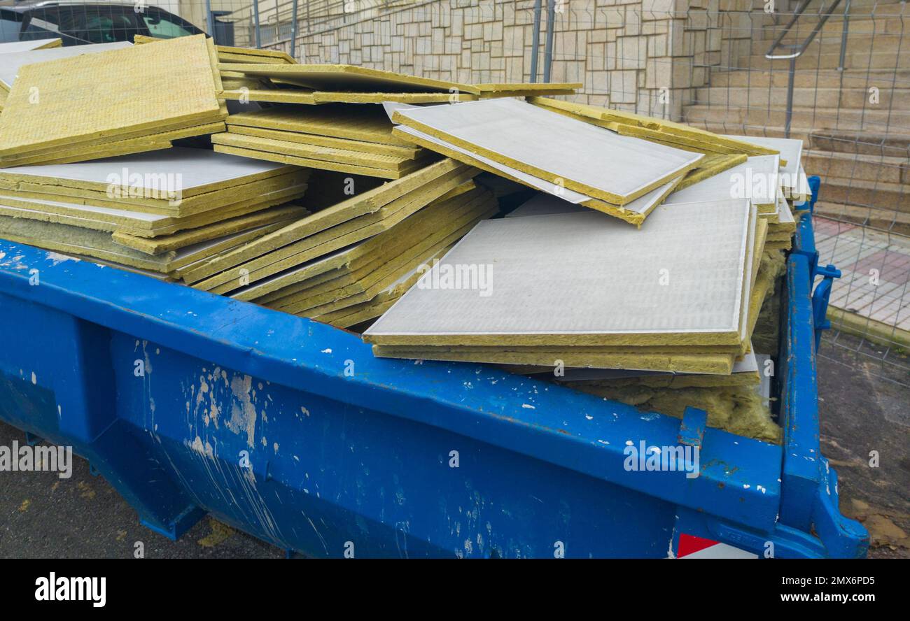 Dumpster pieno di lastre di lana di vetro. Rifiuti di gestione della toilette. Foto Stock
