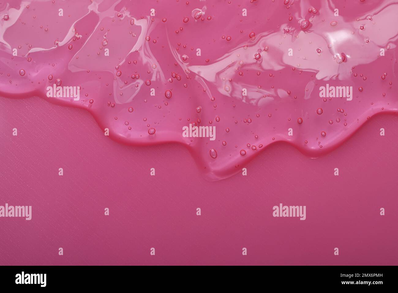 Gel cosmetico trasparente puro su sfondo rosa, vista dall'alto Foto Stock