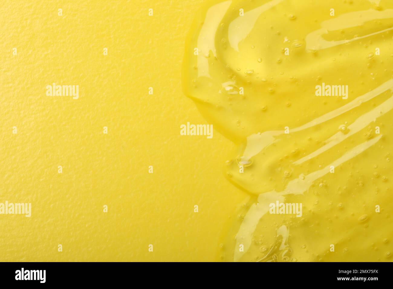 Gel cosmetico trasparente puro su sfondo giallo, vista dall'alto Foto Stock