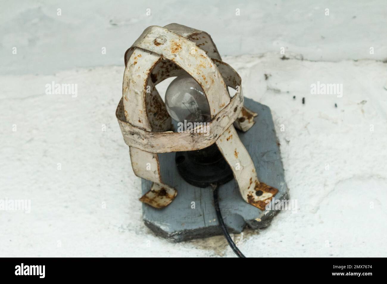 Lampada a incandescenza per esterni in una gabbia antiruggine protettiva. Foto Stock
