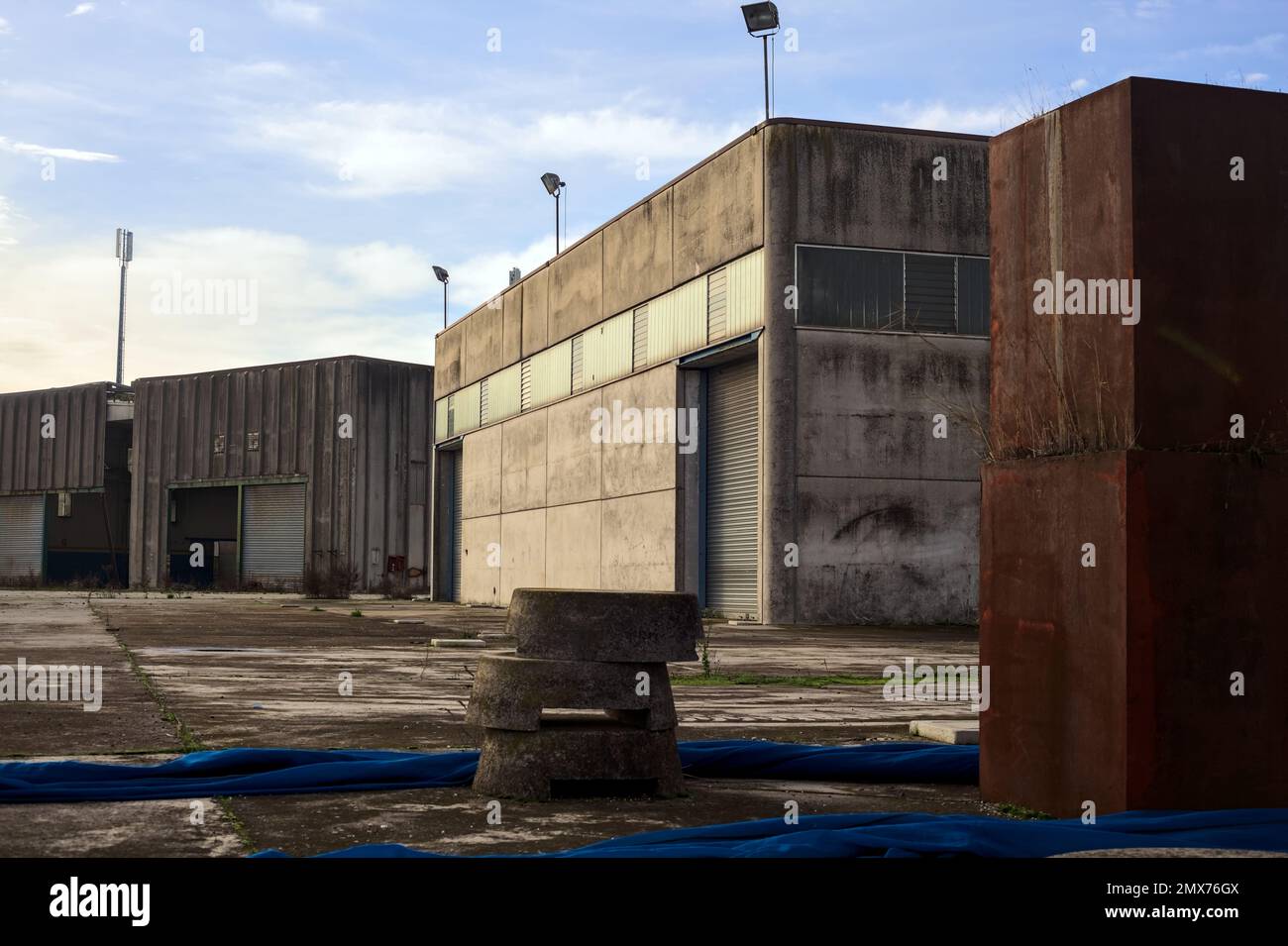 Complesso industriale abbandonato chiuso da un cancello nella campagna italiana Foto Stock