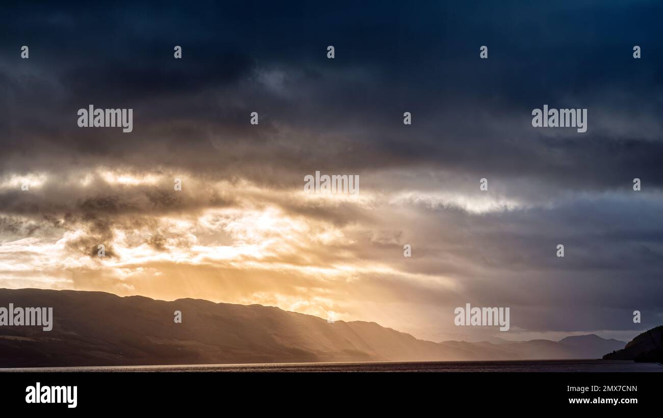 La pioggia spazzerà il Grande Glen spingendo il sole prima di esso, mentre Loch Ness diventa sempre più scuro. Foto Stock