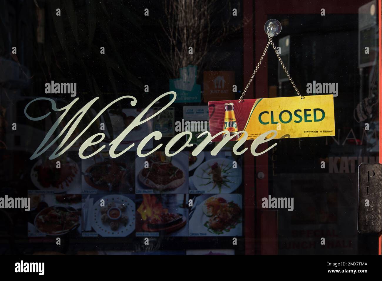 Benvenuto chiuso, messaggio misto alla porta di un ristorante indiano a Edimburgo, Scozia, Regno Unito. Foto Stock