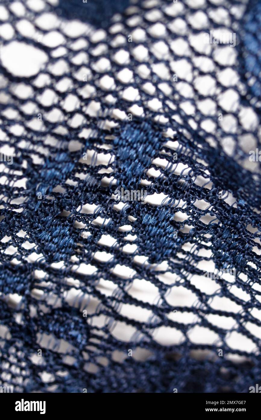 Pizzo fiori su un tessuto blu da vicino Foto Stock