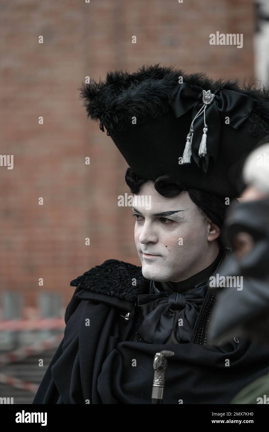 Carnevale di Venezia. Un uomo con un volto coperto da uno strato di polvere  bianca nello stile di un'aristocrazia medievale in costume nero carnevale -  cappello alto Foto stock - Alamy
