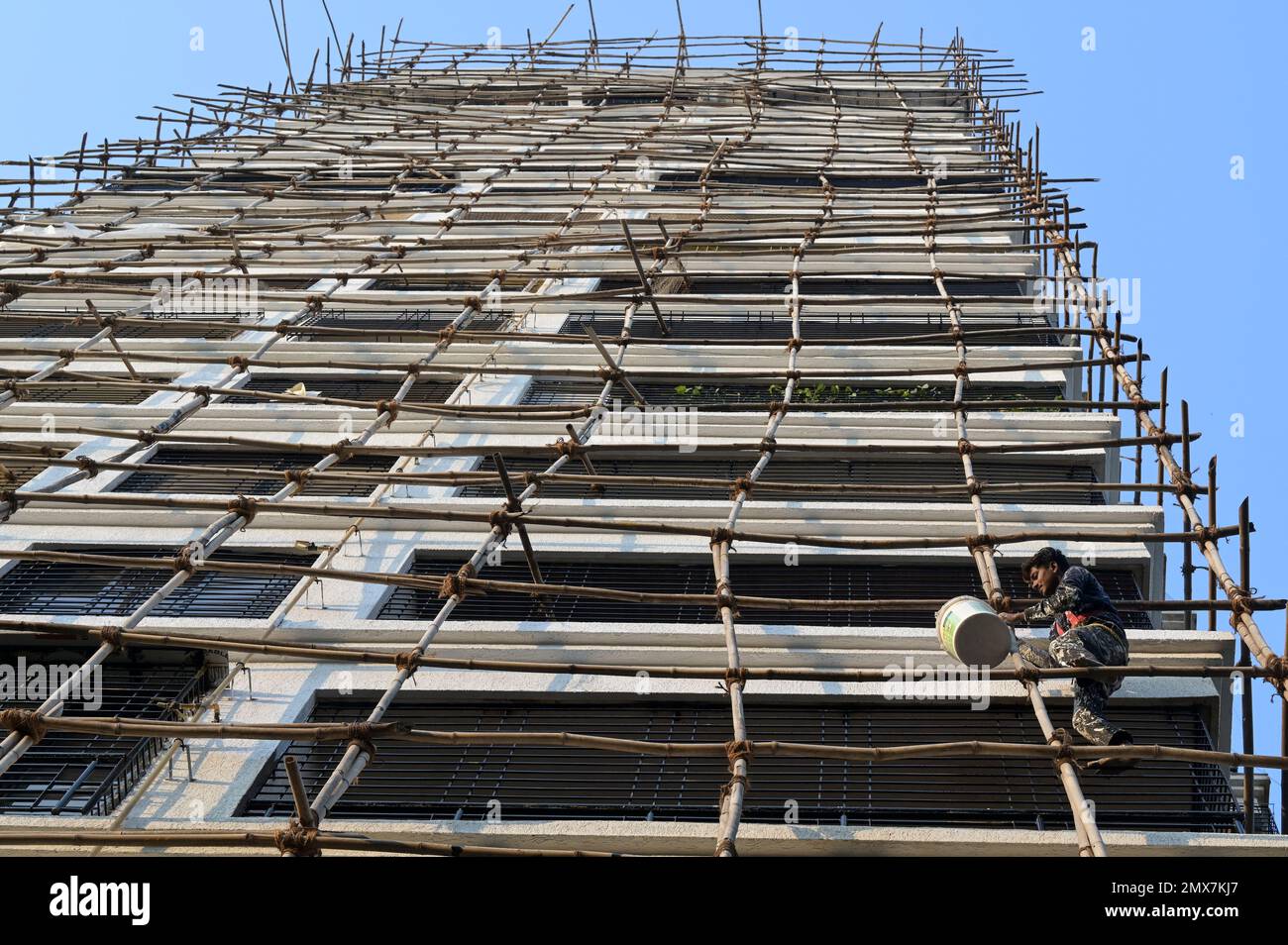 INDIA, Mumbai, torre di appartamenti in fase di ristrutturazione,  impalcatura di bambù, lavoratore migrante da UP e Bihar che fanno lavori di  verniciatura / INDIEN, Mumbai, Wohnhaus mit Baugerüst aus Bambus,  Wanderarbeiter