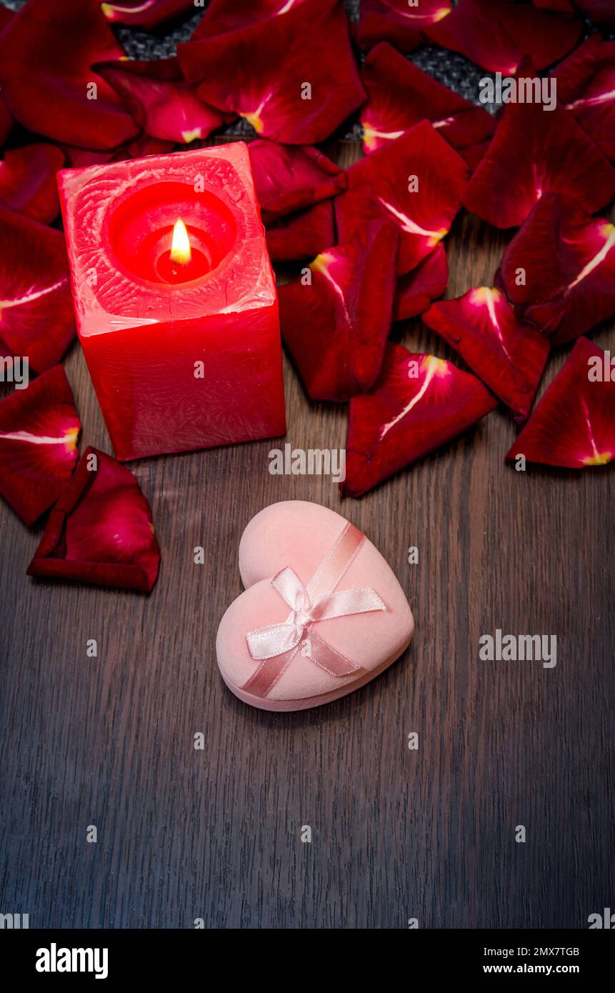 candela, rosa petalo rosso con scatola regalo sul tavolo. concetto sfondo san valentino Foto Stock