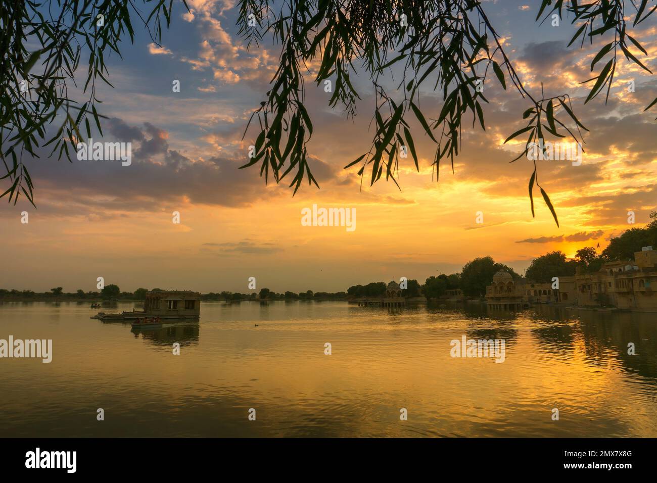 Bellissimo tramonto sul lago Gadisar, Jaisalmer, Rajasthan, India. Sole e nuvole colorate nel cielo con vista sul lago Gadisar. Foto Stock