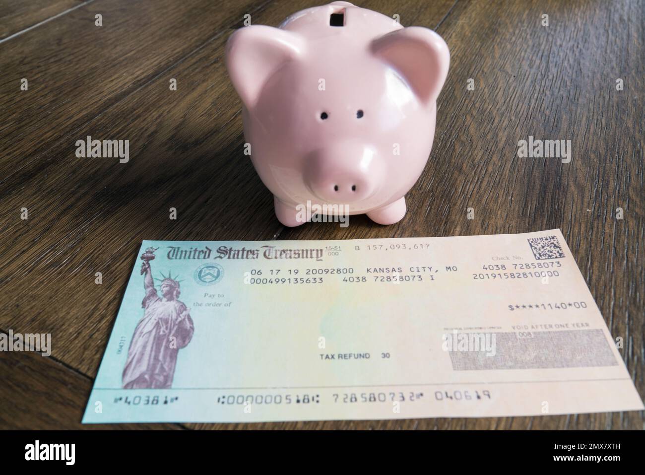 Controllo rimborso tasse con banca rosa piggy Foto Stock