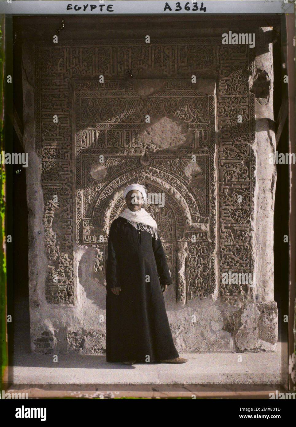 Cairo, Egitto, Africa Un uomo si pone davanti a un segno della moschea di Ibn Tûlûn , 1914 - Egitto - Auguste Léon - (gennaio-febbraio) Foto Stock