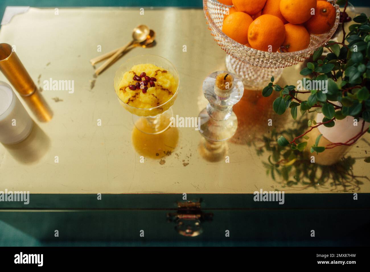 Vita morta con il dessert di riso allo zafferano persiano, Sholeh Zard, sul tronco d'oro del tavolo Foto Stock