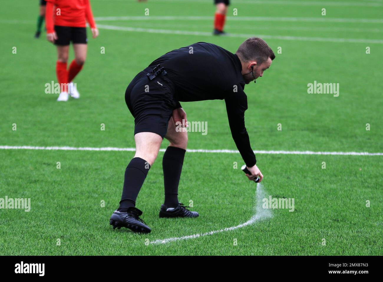 L'arbitro del calcio gallese segna la linea difensiva della parete con l'arbitro che svanisce lo spray Foto Stock L'arbitro del calcio gallese segna la linea difensiva della parete con l'arbitro che svanisce lo spray Foto Stock