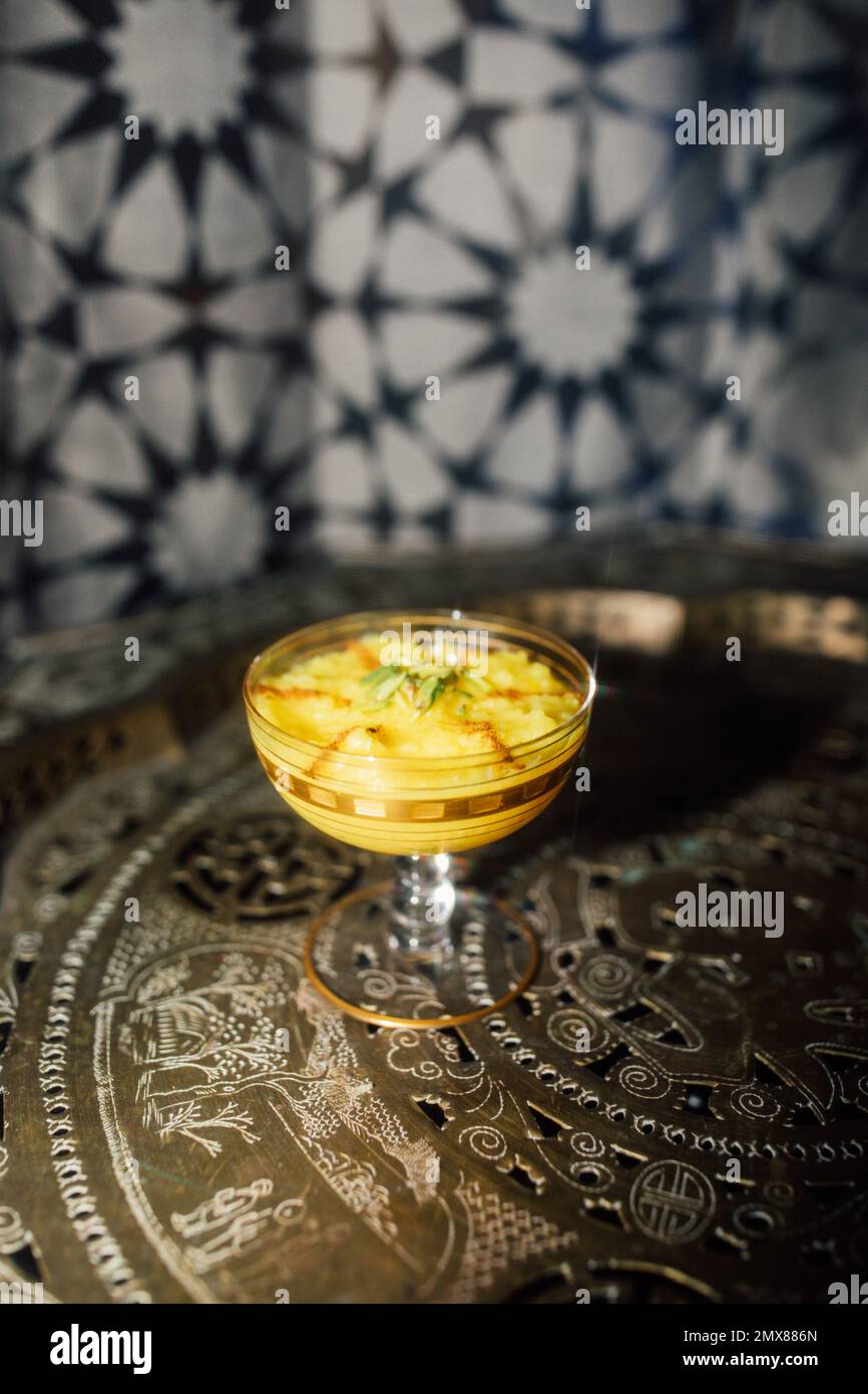 Sholeh Zard, un budino di riso allo zafferano persiano, dessert con crema di pistacchio e cannella Foto Stock