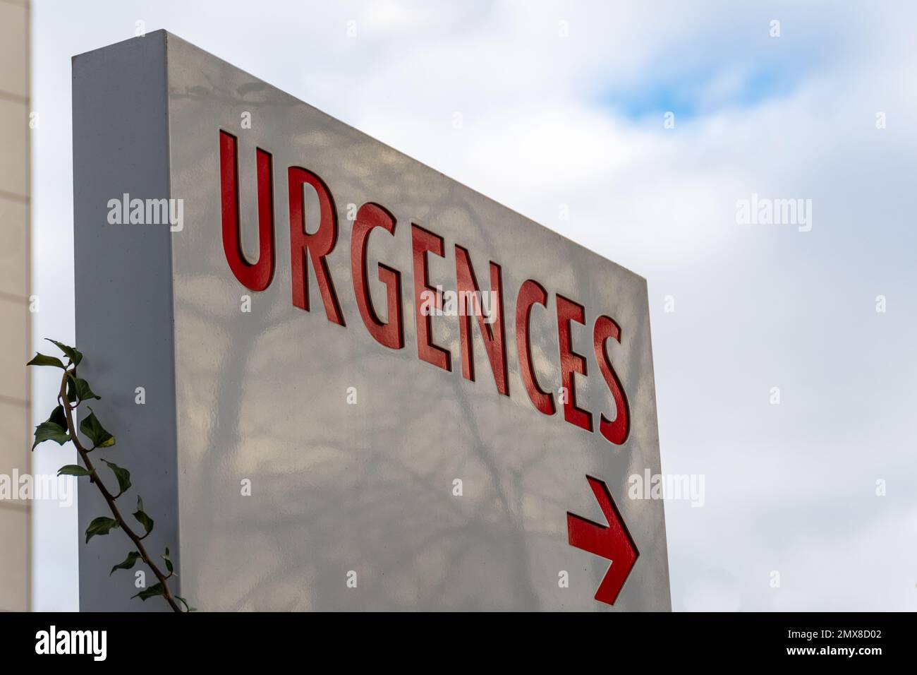 Firma con la parola francese 'URGENZE' (che significa 'EMERGENZE') scritta in rosso che indica la direzione del pronto soccorso in un ospedale Foto Stock