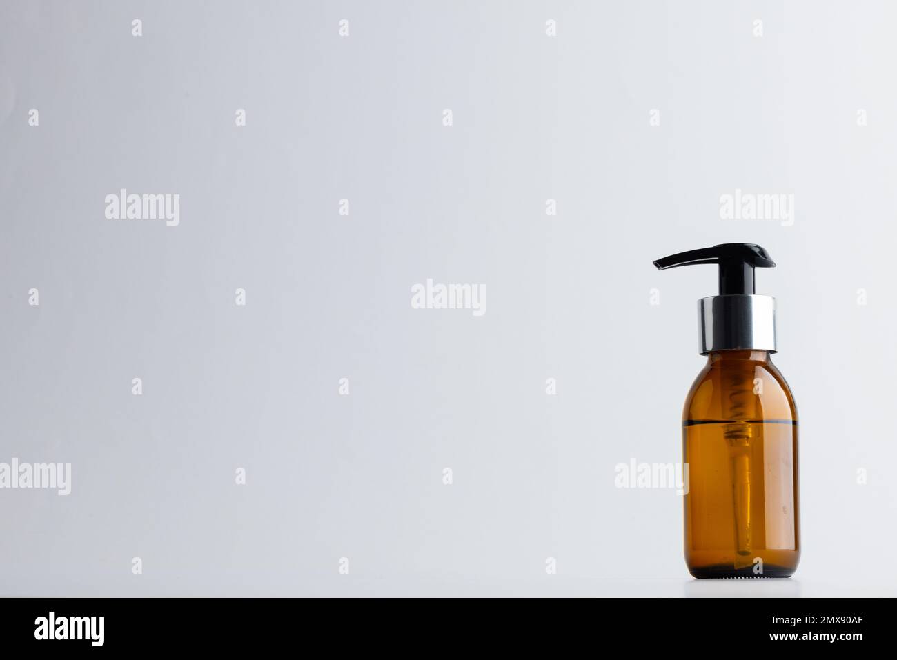Immagine della bottiglia di vetro con pompa e spazio copia su sfondo bianco Foto Stock