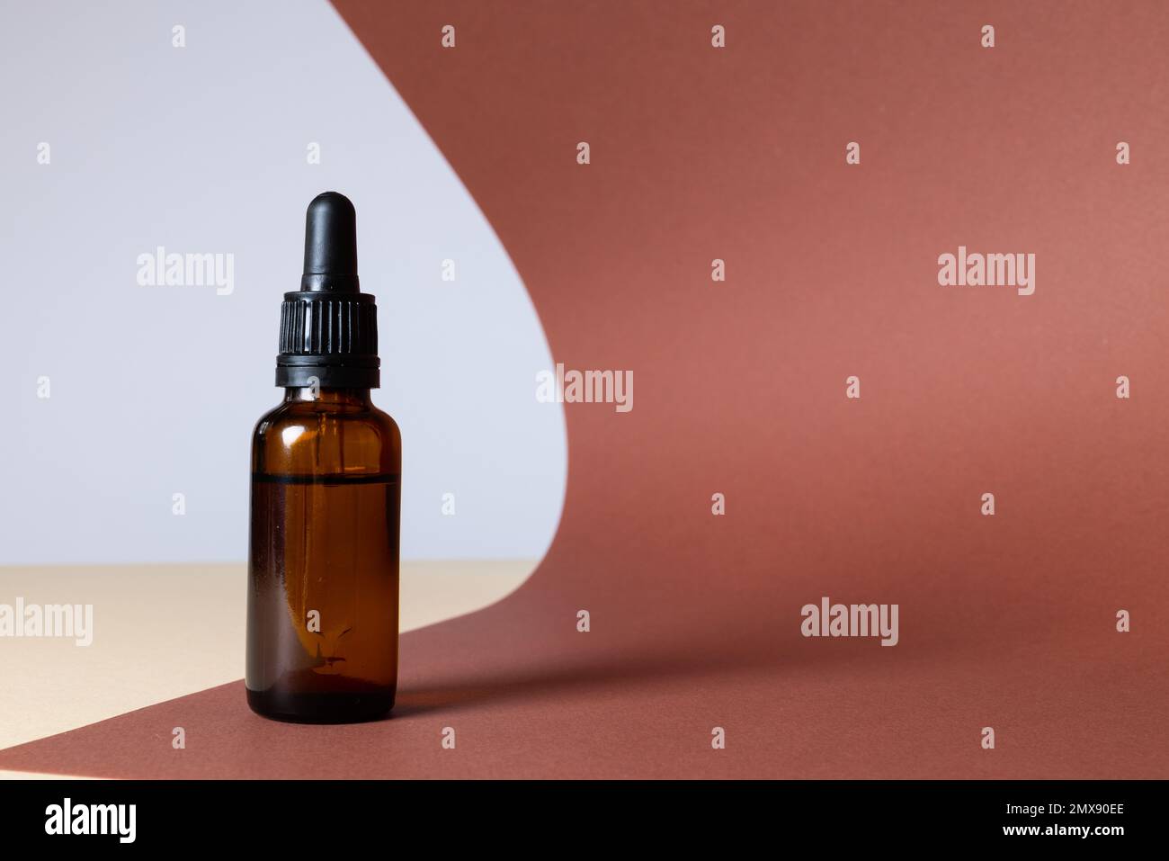 Immagine della bottiglia di vetro con pompa e spazio copia su sfondo marrone Foto Stock