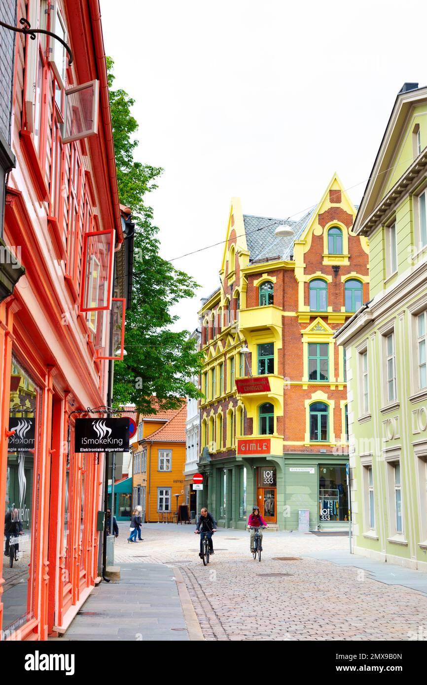 Edifici colorati e persone in bicicletta lungo Kong Oscars Gate, Bergen, Norvegia Foto Stock