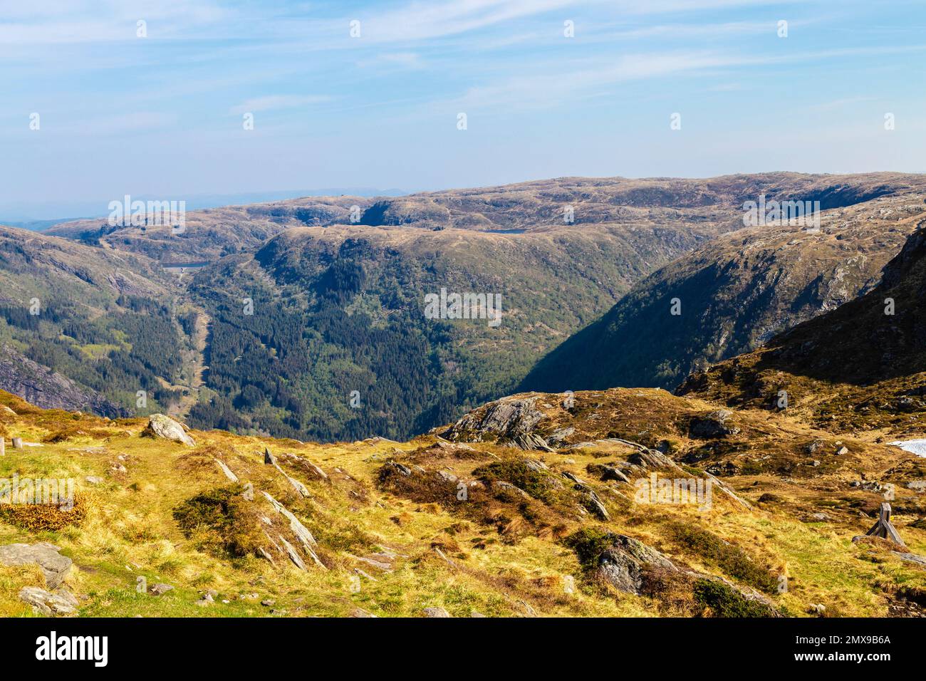 Persone che si siedono su rocce che guardano una vista panoramica dalla cima del monte Ulriken a Bergen, Norvegia Foto Stock