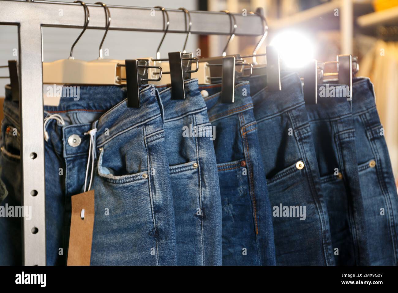 Jeans moderni appesi al portabiti in negozio, guardaroba Foto stock - Alamy
