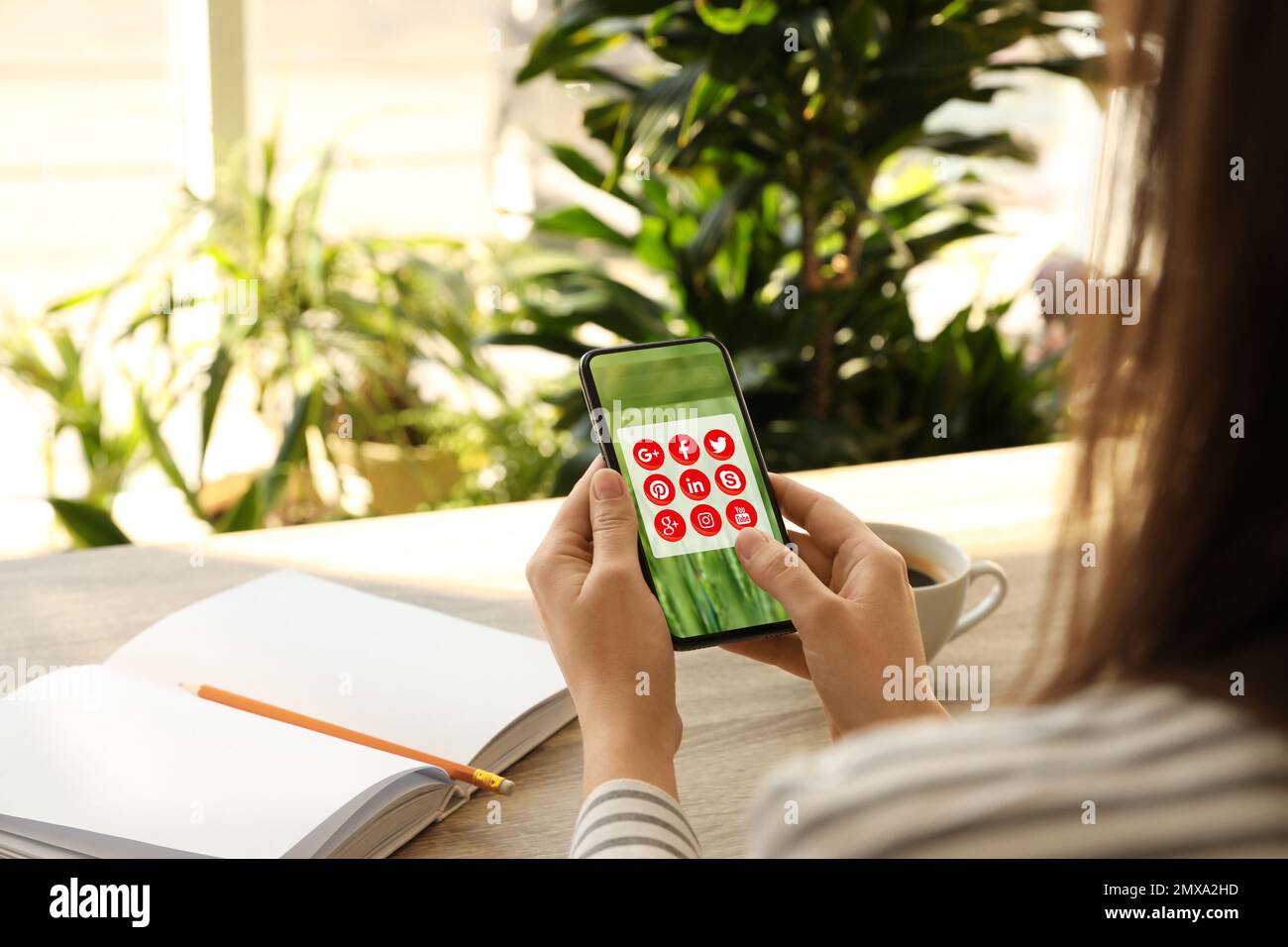 MYKOLAIV, UCRAINA - 30 APRILE 2020: Donna che tiene il telefono con le icone delle app dei social media sullo schermo in interni, primo piano Foto Stock