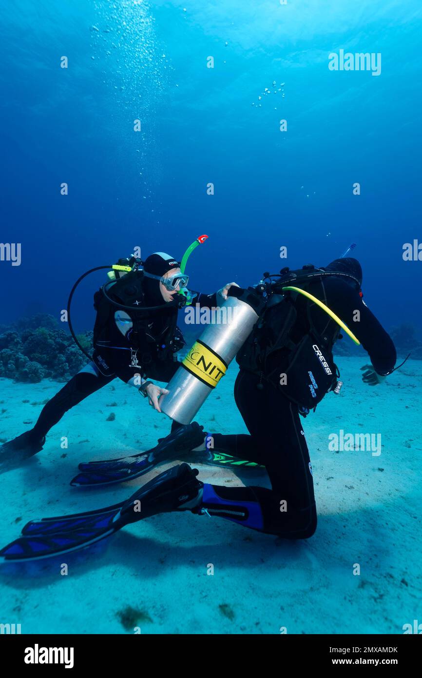 Sub aiuta altri subacquei, sciolto scuba, nitrox, Port Safaga, Mar Rosso, Egitto Foto Stock
