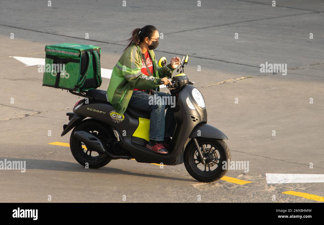SAMUT PRAKAN, THAILANDIA, 30 2023 GENNAIO, Una donna con scatola di stoccaggio ride una moto Foto Stock