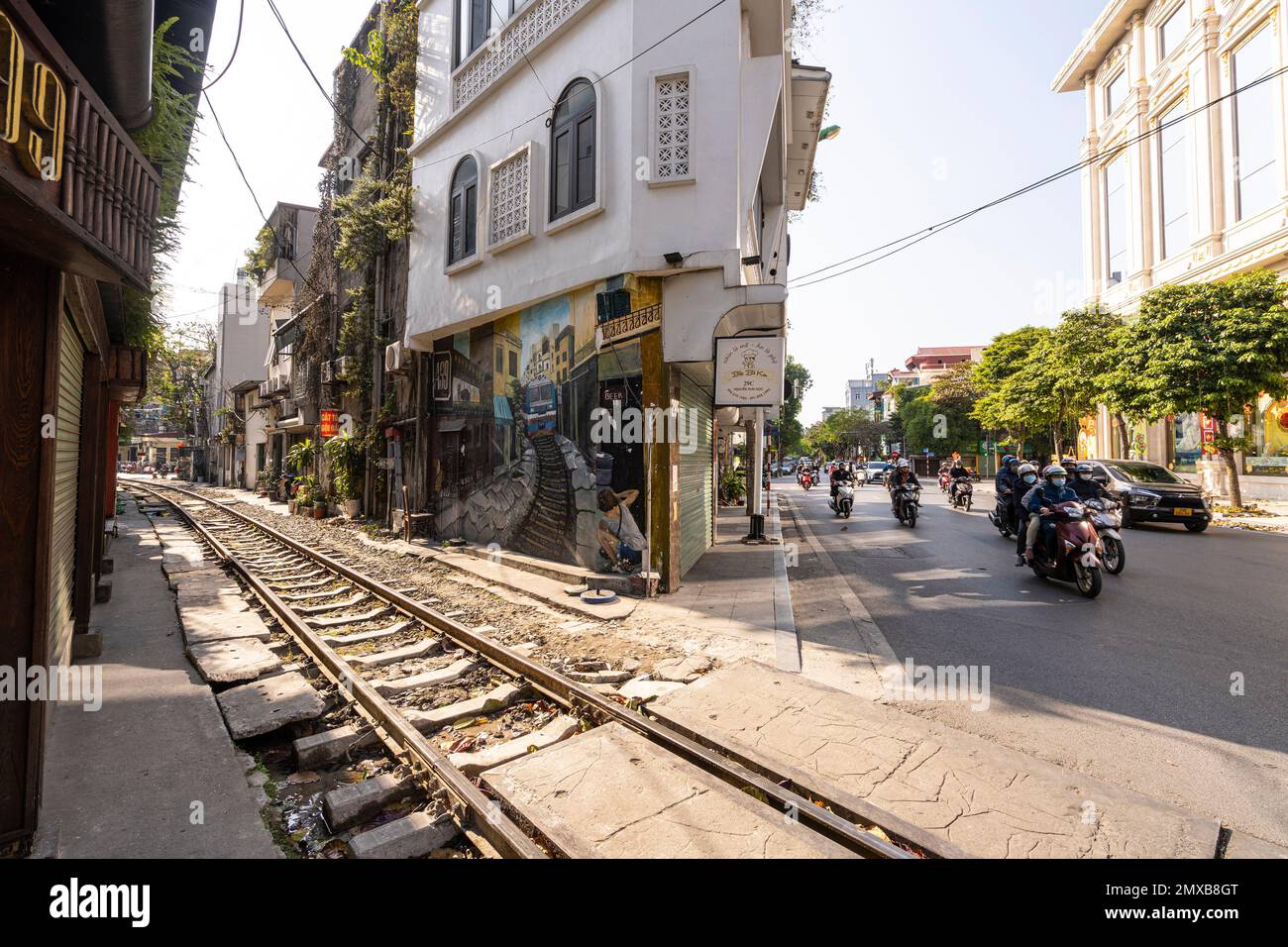 Hanoi, Vietnam, gennaio 2023. il passaggio di un treno lungo i binari tra le case del centro storico Foto Stock