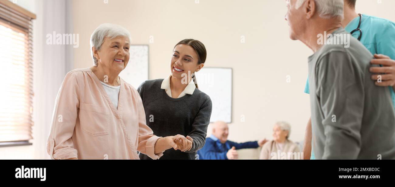 Operatori sanitari che aiutano i pazienti anziani a camminare nell'ospizio geriatrico. Design del banner Foto Stock